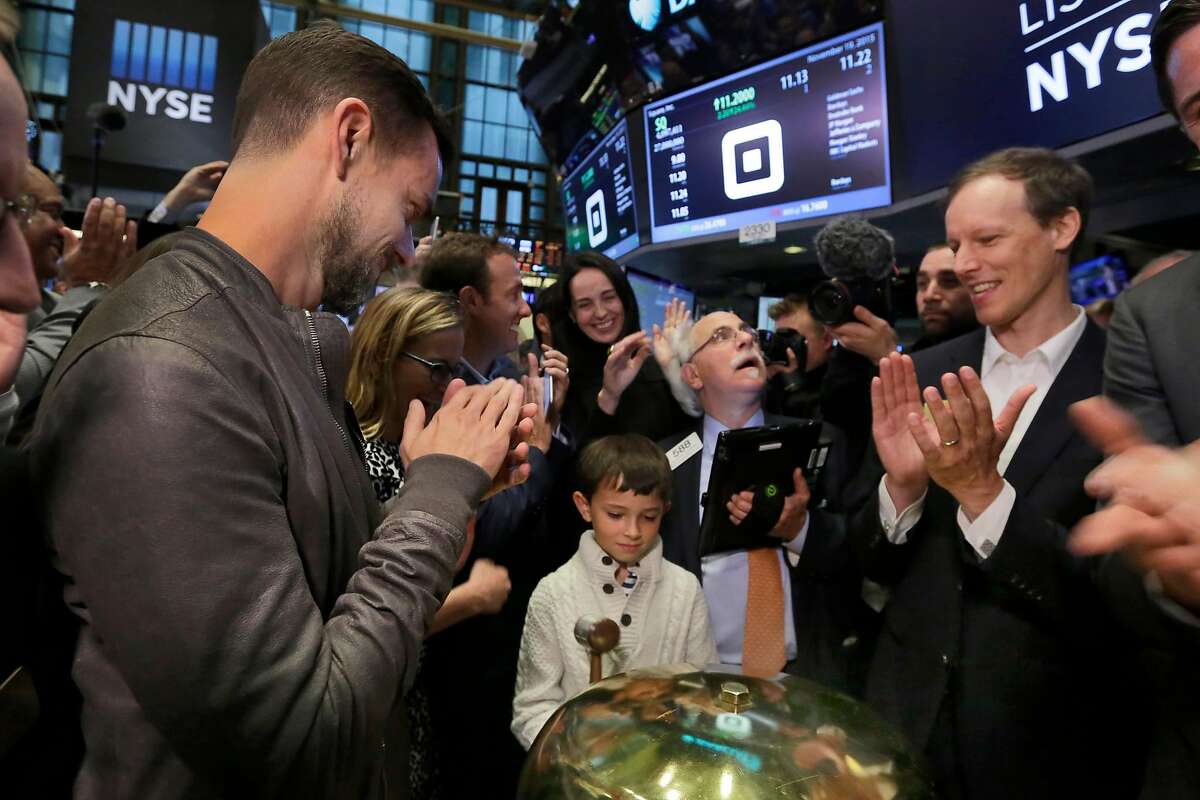 Mac Riley, center, son of Square CFO Sarah Friar, rings a ceremonial bell as the Square IPO begins trading, on the floor of the New York Stock Exchange, Thursday, Nov. 19, 2015. Flanking Riley are Square CEO Jack Dorsey, left, and co-founder Jim McKelvey, far right. Square, the 6-year-old startup known for its white, cube-shaped card readers that plug into smartphones, is surging in its first day as a publicly traded company. (AP Photo/Richard Drew)