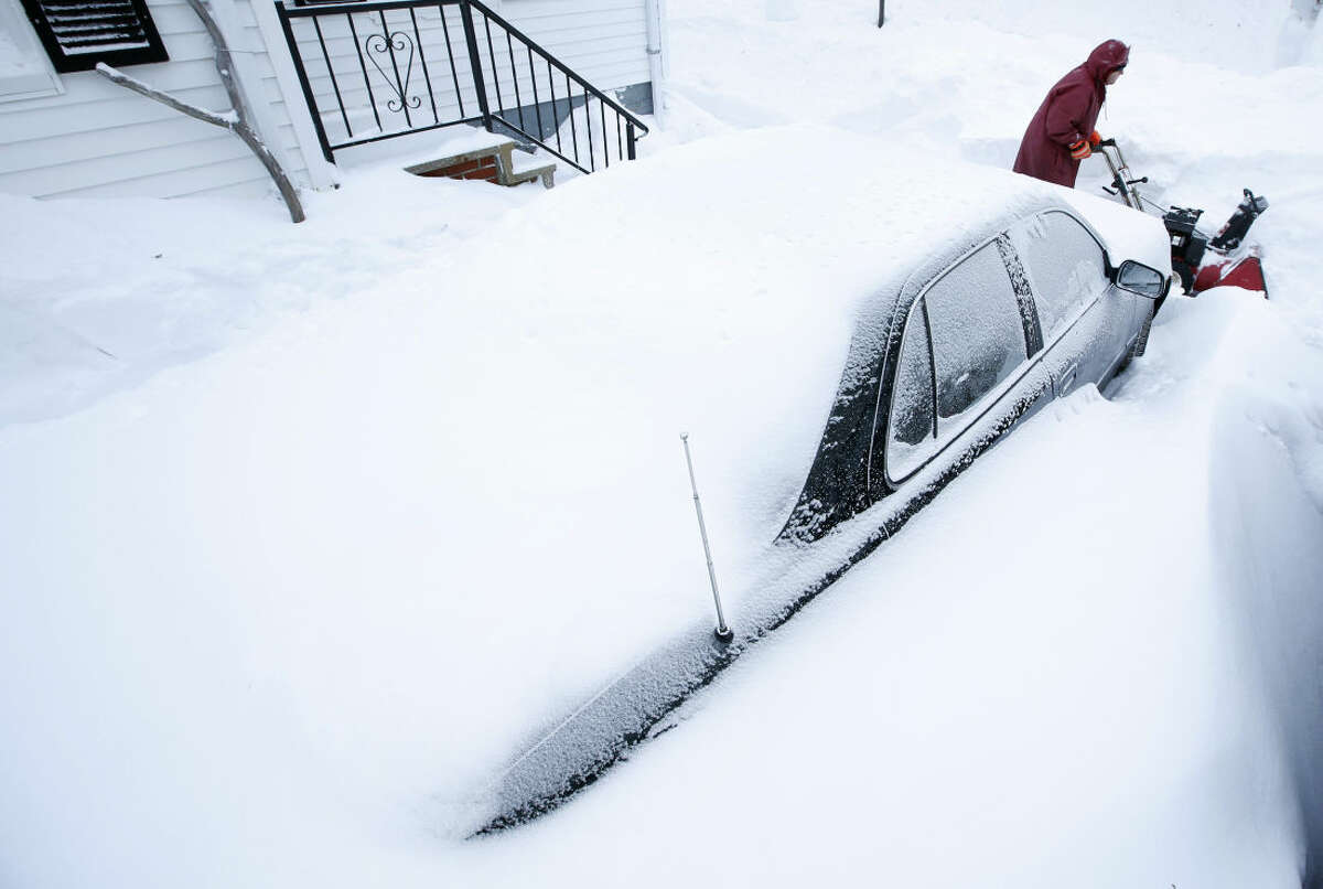 Phil Curran, 71, uses a snowblower to dig out a car that was buried in a snowdrift after a winter storm, Wednesday, Jan 28, 2015, in Portland, Maine. Tuesday's blizzard dumped about two feet of snow in Portland. (AP Photo/Robert F. Bukaty)