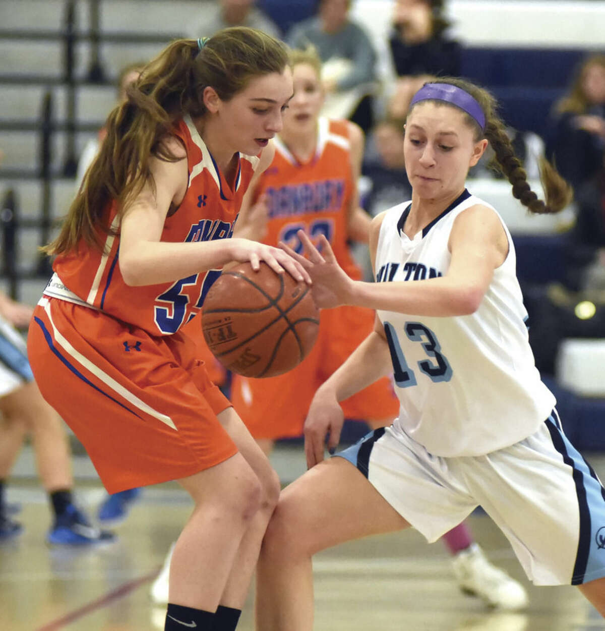 Hour photo/John Nash - Wilton's Makenna Pearsall, right, steals the ball from Danbury's Emily Broggy during Thursday's FCIAC girls basketball game in Wilton. The host Warriors won the game, 67-25.