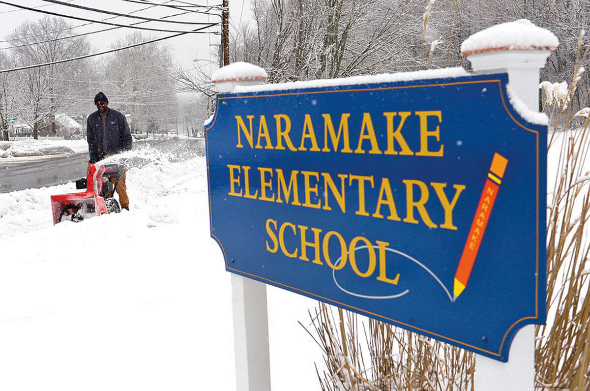 Hour photo / Erik Trautmann Norwalk Recreation and Parks employee Marvin Sanders cleans up after a light snowfall Friday morning that caused delayed openings for Norwalk Public Schools.