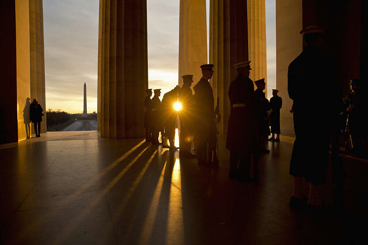 As the sun rises, military personnel practice their positioning during a rehearsal before a Presidential Full Honor Wreath-Laying Ceremony in celebration of the 207th birthday of President Abraham Lincoln, Friday, Feb. 12, 2016, at the Lincoln Memorial Washington. (AP Photo/Alex Brandon)