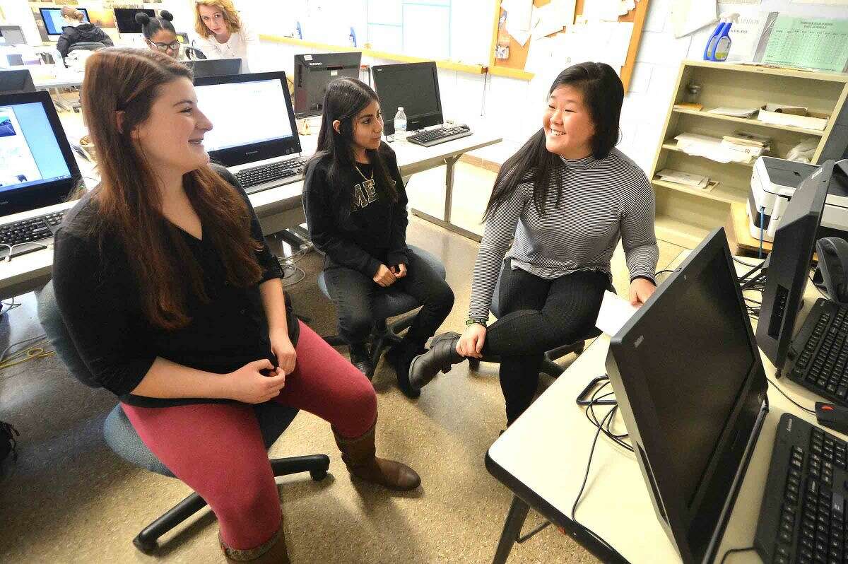 Hour Photo/Alex von Kleydorff Norwalk High School Journalism students Sports Editor Hannah Keyes, Reporter Maria Saldana and Arts and Life Co Editor Jannalee Potmesil discuss the next issue of the schools newspaper The Paw Print during Journalism class