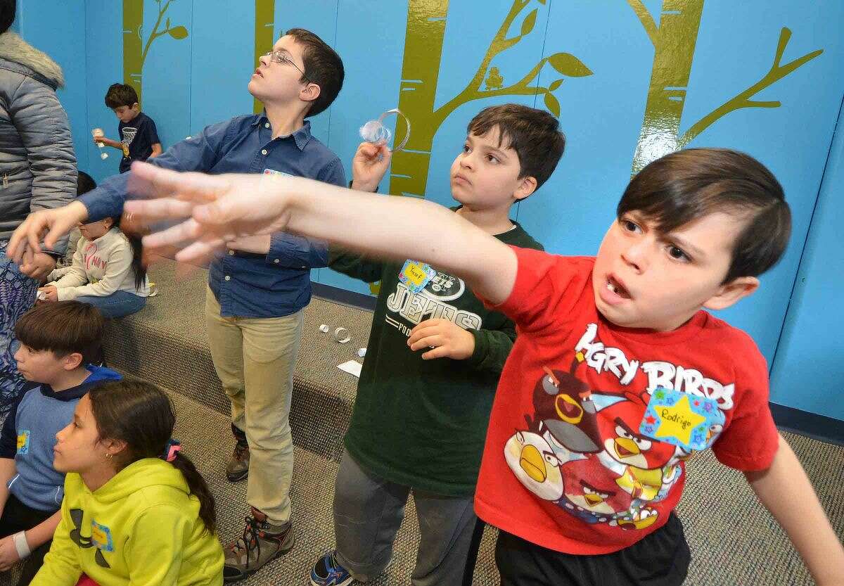 Hour Photo/Alex von Kleydorff Rodrigo Torres along with the group get their Hoop Gliders into the air during Super Science at The Norwalk Public Library