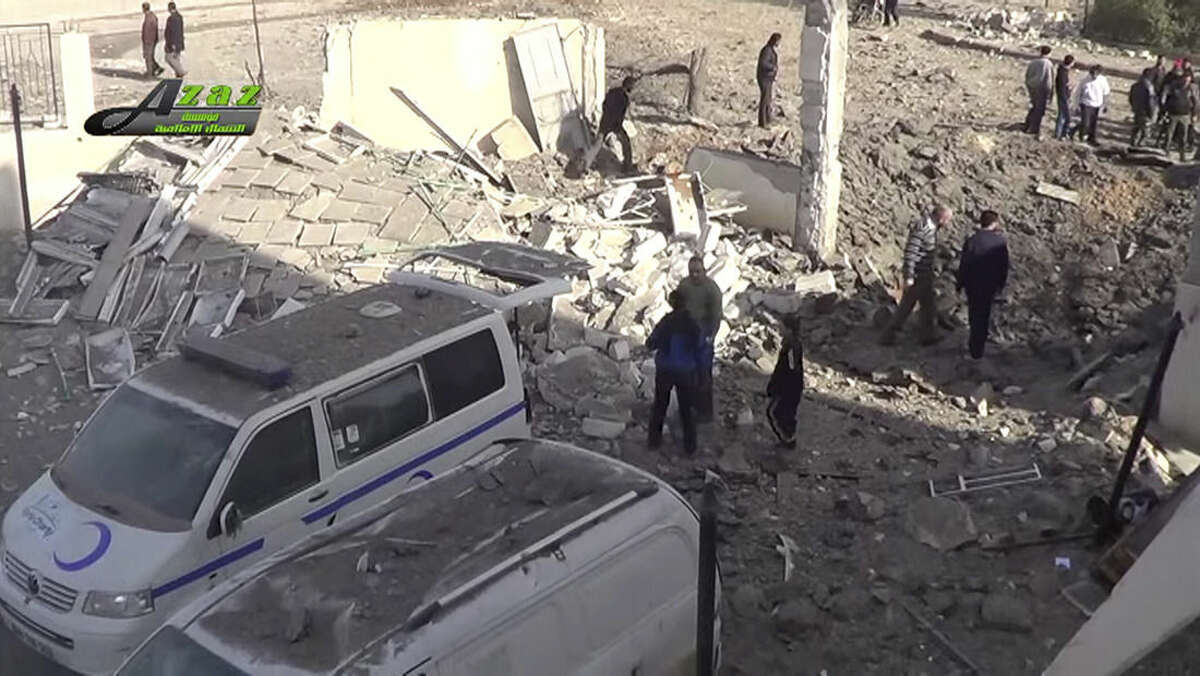 This image taken from video provided by the Syrian activist-based media group Azaz Media Center, which has-been verified and is consistent with other AP reporting, shows people gathered around destroyed vehicles in Azaz, Syria Syria, Monday, Feb. 15, 2016. Turkey says Kurdish forces have been expelled from areas around the northern Syrian town of Azaz after a weekend of cross-border shelling.(Azaz Media Center,via AP Video) MANDATORY CREDIT