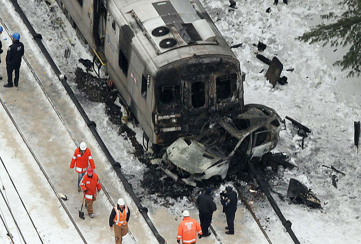 Personnel from various agencies work the scene of a deadly commuter train accident in Valhalla, N.Y., Wednesday, Feb. 4, 2015. The packed Metro-North Railroad train slammed into a SUV stuck on the tracks and erupted into flames Tuesday night, killing some and injuring others, sending hundreds of passengers scrambling for safety, authorities said.(AP Photo/The Journal-News, Frank Becerra Jr.) NYC OUT, NO SALES