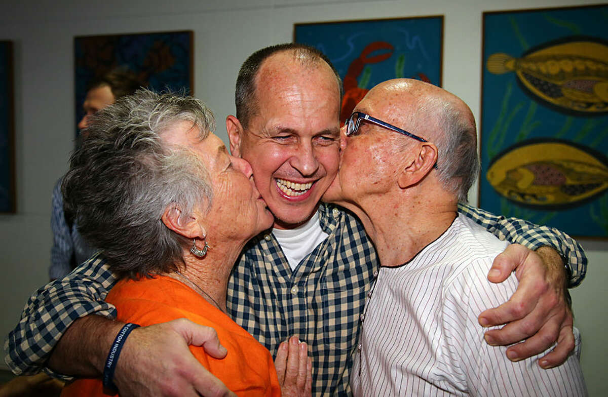 Australian journalist Peter Greste is hugged by his mother Lois, left, and father Juris, right, after his arrival in Brisbane, Australia, Thursday, Feb. 5, 2015. Greste, a reporter for Al-Jazeera English was released from an Egyptian prison and deported after more than a year behind bars. (AP Photo/Tertius Pickard)