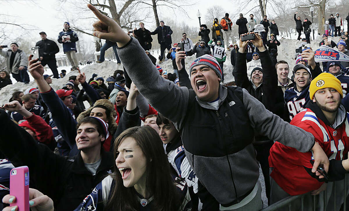New England Patriots fans cheer as duck boats carrying players pass during a parade in Boston, Wednesday, Feb. 4, 2015, to honor the NFL football team's victory over the Seattle Seahawks in Super Bowl XLIX in Glendale, Ariz. (AP Photo/Charles Krupa)