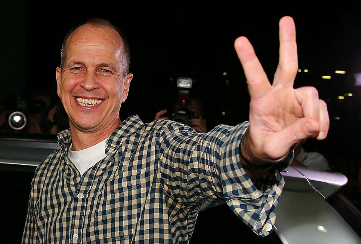 Australian journalist Peter Greste gestures after his arrival in Brisbane, Australia, Thursday, Feb. 5, 2015. Greste, a reporter for Al-Jazeera English was released from an Egyptian prison and deported after more than a year behind bars. (AP Photo/Tertius Pickard)