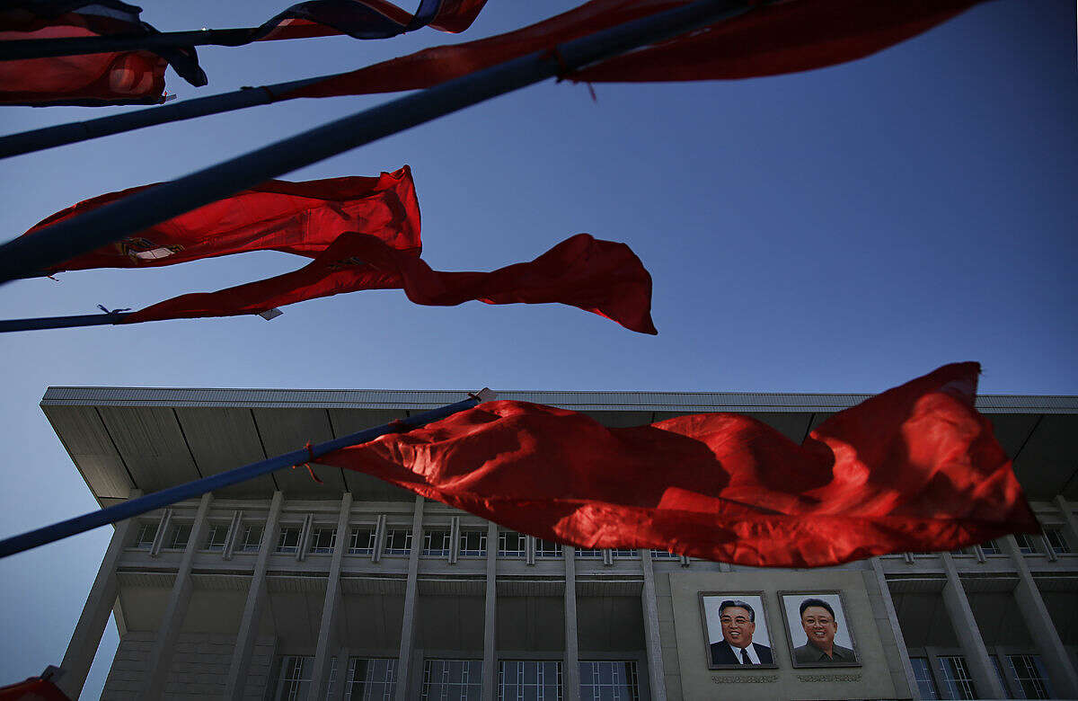 Portraits of the late leaders Kim Il Sung, left, and Kim Jong Il, right, hung at the entrance of the Pyongyang Indoor Stadium are seen in the background as North Korean national flags and Youth League flags decorate the venue on the "Day of the Shining Star" or birthday anniversary of Kim Jong Il on Tuesday, Feb. 16, 2016, in Pyongyang, North Korea. The celebrations of the late Kim Jong Il's birthday anniversary, a revered national holiday, came as South Korea’s president warned that North Korea faces collapse if it doesn’t abandon its nuclear weapons program, amid an international outcry over Pyongyang’s January nuclear test and the Feb. 7 rocket launch. (AP Photo/Wong Maye-E)