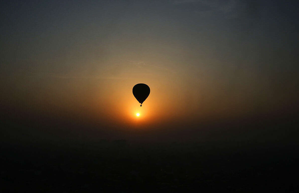 A hot air balloon flies against a sun rise during Lucknow balloon festival in Lucknow, India, Monday, Feb. 15, 2016. The three-day festival is to boost the tourism and generate more employment opportunities in the state of Uttar Pradesh. (AP Photo/Rajesh Kumar Singh)