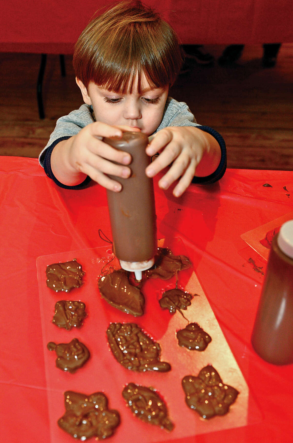 Hour photo / Erik Trautmann 2 year old Jack Burton makes chocolate during the Wilton Historical Society annual Valentine Chocolate-Making Workshop for kids in grades kindergarten through 8 Thursday. Program participants also made Valentines cards box to put the chocolates in. The one-hour session made use of an extensive collection of small, charming chocolate mold featuring hearts, a multitude of animals, and stars.