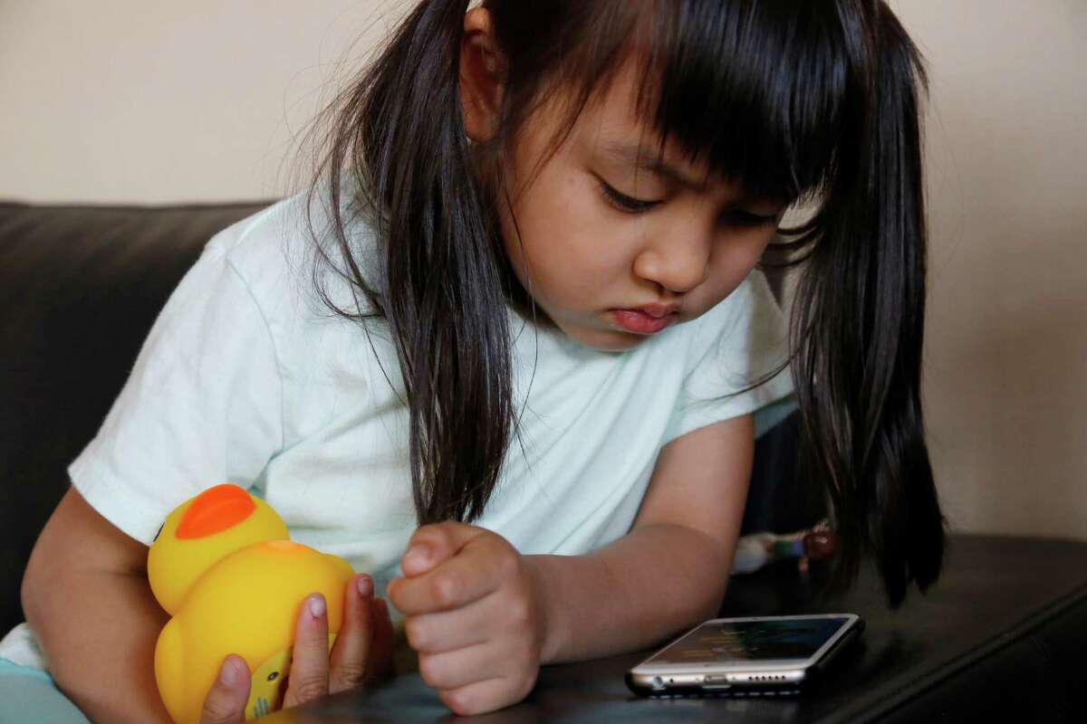 In this May 23, 2016, photo, Kano Matusmoto, 5, plays with Edwin the Duck, a digital duck toy, in the living room of her home in Tokyo. Edwin the Duck, billed as the worldÂ?’s first Â?“smart duck,Â?” connects by Bluetooth with a smartphone or tablet device such as an iPad to play animation stories and songs. It also works as a regular speaker to deliver music of your choice in bed or in the bathtub. (AP Photo/Yuri Kageyama)