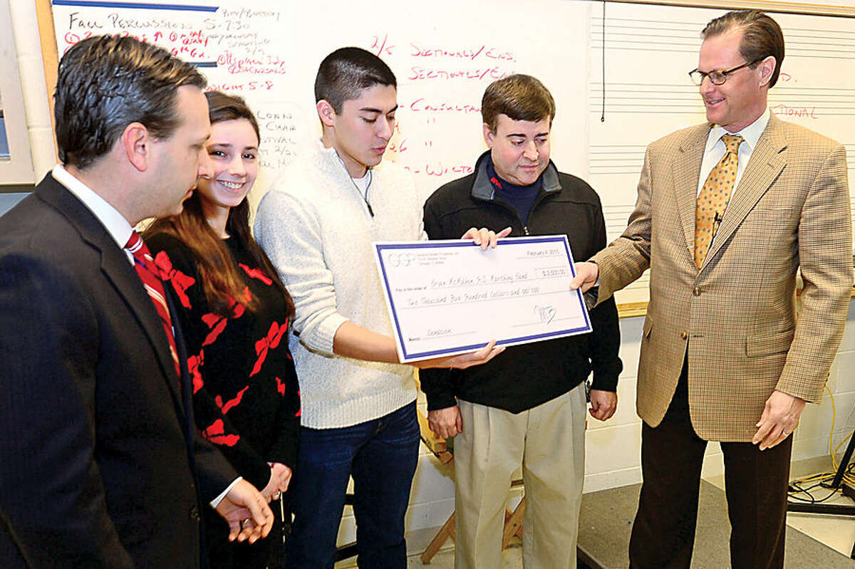 Hour photo / Erik Trautmann State Senator Bob Duff, left, and Doug Adams, Senior Director, General Growth Properties, right, visit the Brien McMahon High School Band to present the Band Director Ron Secchi, second from right, and drum majors Elle Buelesbach and Sam Starkman with a check for $2,500, to make up for the loss of revenue after a power outage forced the school to cancel the remaining portion of a Brien McMahon High School Band’s largest annual fundraiser, the “Celebration of Sound,” band competition.