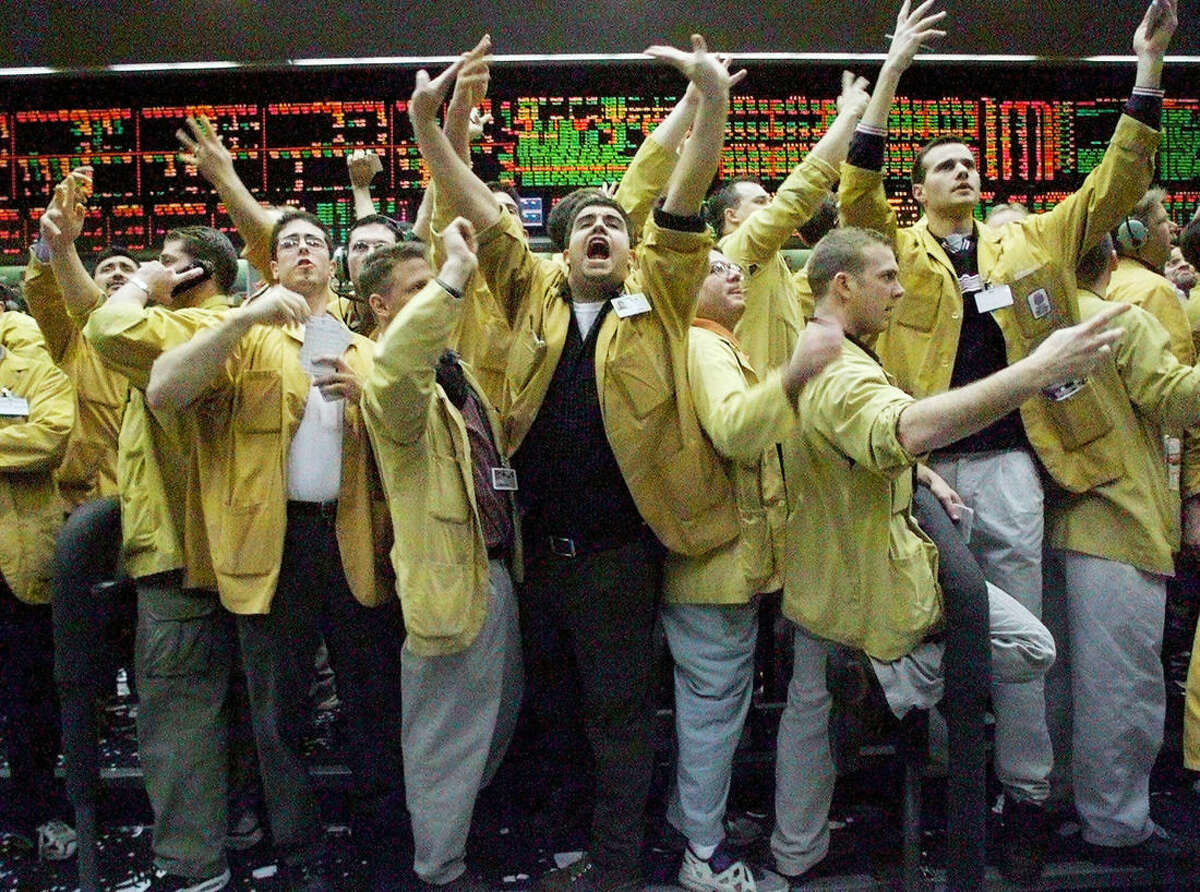 FILE - In this Dec. 21, 1999 file photo, Nicholas Torres, center, shouts an order in the eurodollar pit at the Chicago Mercantile Exchange just as the Fedeal Reserve was announcing that there would be no change in interest rates. Floor trading has shrunk to a fraction of its volume from two decades ago as faster, cheaper, computers take over the process of establishing prices on everything from pigs to Exxon Mobil’s stock. (AP Photo/Beth A. Keiser)