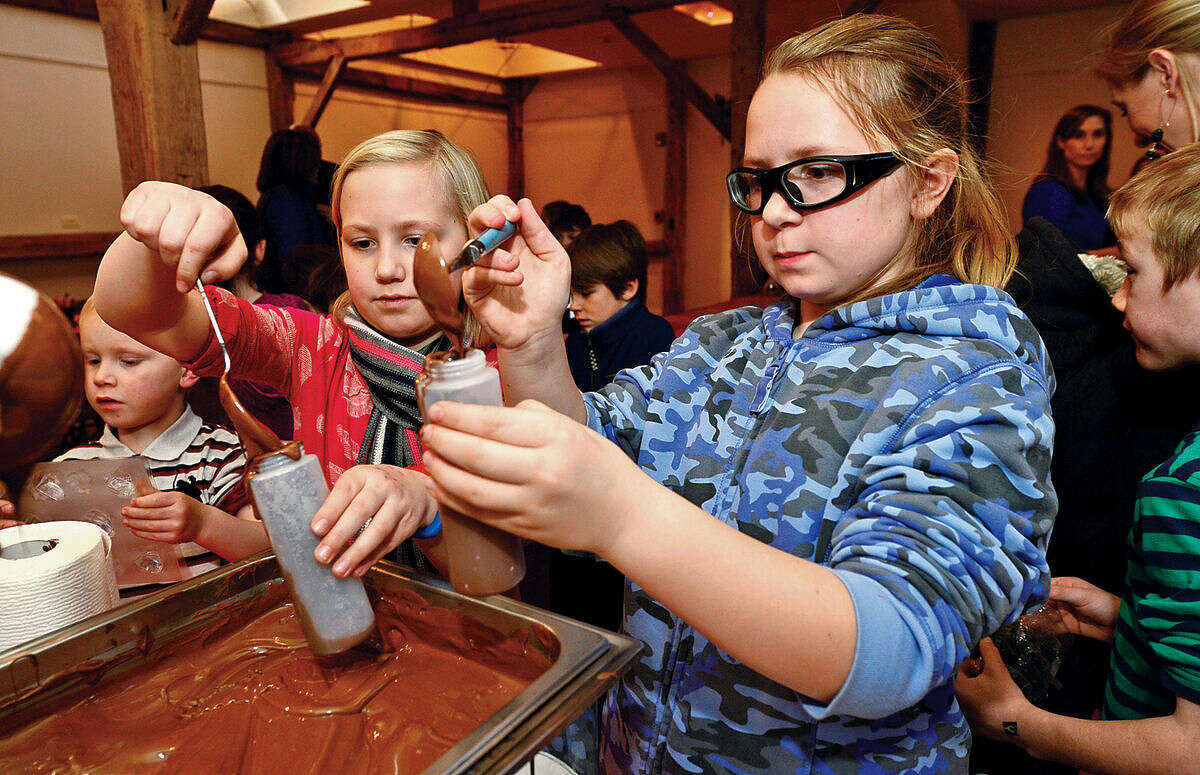 Ava and Amelia Fleming, 9 and 8, make chocolate during the Wilton Historical Society's 3rd annual Valentine Chocolate-Making Workshop for kids in grades kindergarten through eight Thursday. Program participants also made Valentine's cards box to put the chocolates in. The one-hour session made use of an extensive collection of small, charming chocolate mold featuring hearts, a multitude of animals, and stars.