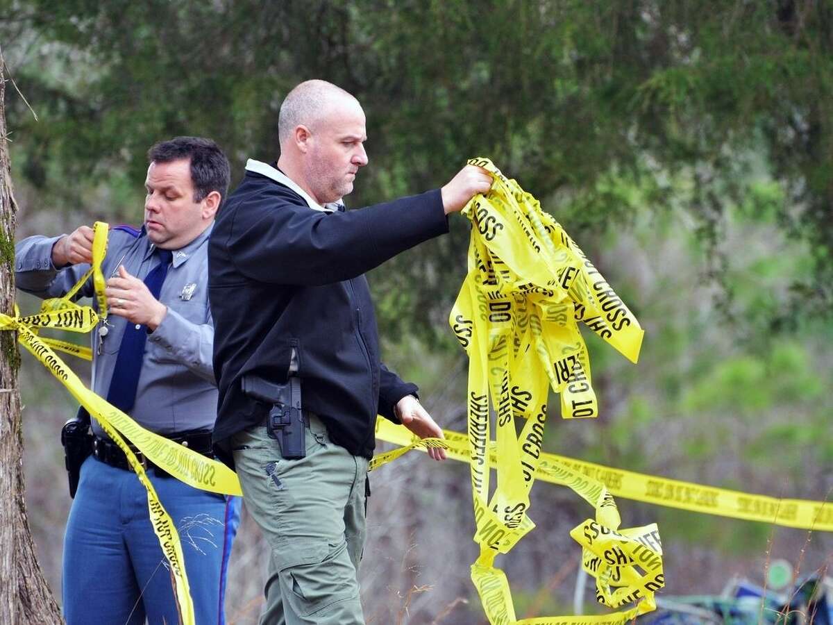 Officers place crime scene tape at the scene of a shooting near Iuka, Miss., Saturday, Feb. 20, 2016. Multiple law enforcement officers were injured after an hourslong standoff in rural north Mississippi ended in fatal gunfire, authorities said. (AP Photo/Michael H. Miller)