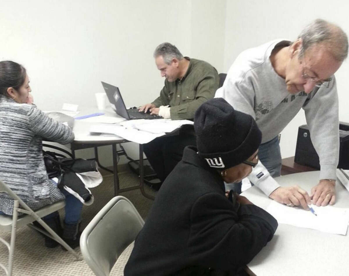 Hour file photo Tax preparers help people with their income taxes in this undated file photo.