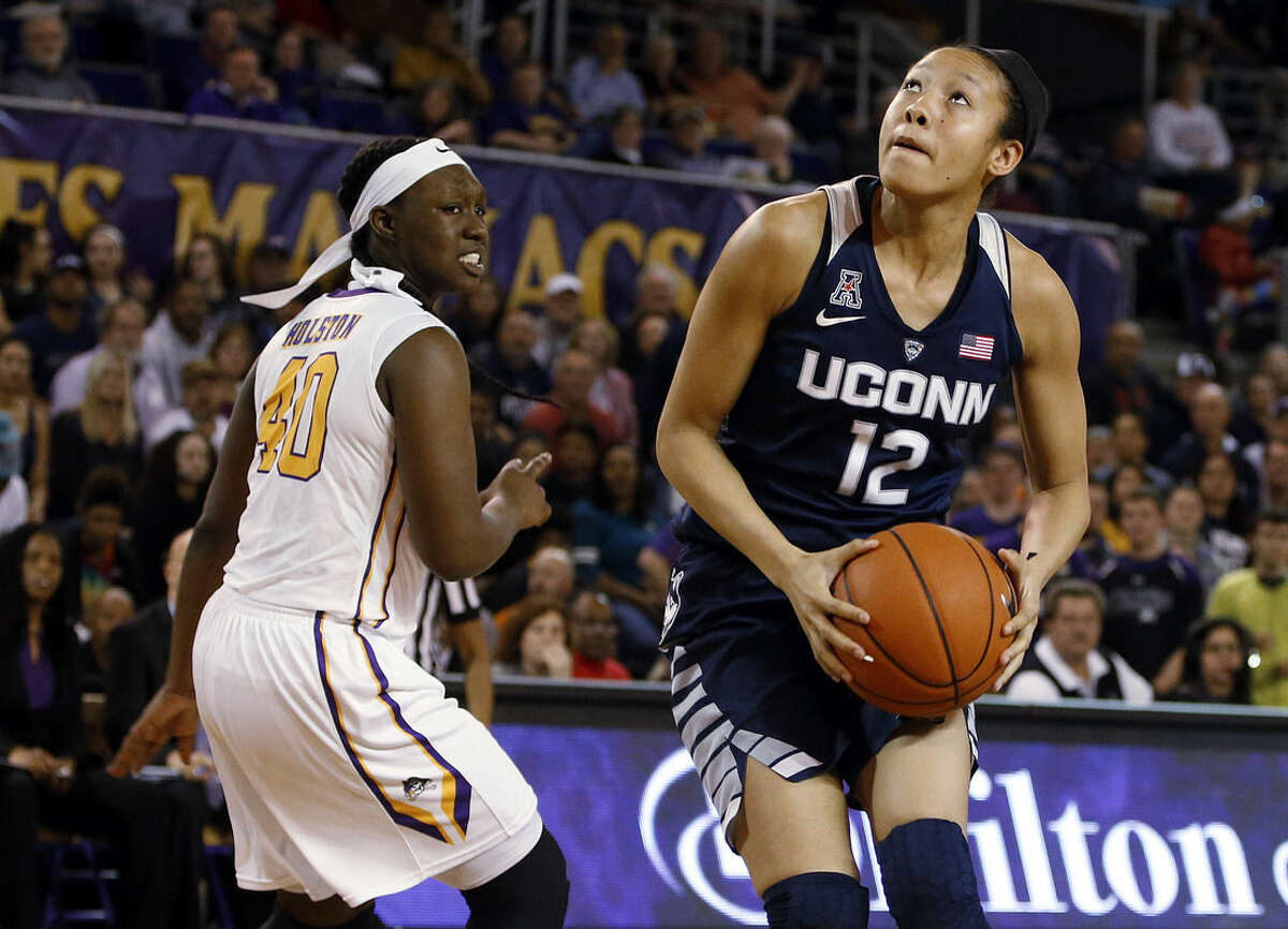 Connecticut's Saniya Chong (12) looks to shoot after dodging East Carolina's Gabrielle Holston (40) during the first half of an NCAA college basketball game Saturday, Feb. 20, 2016, in Greenville, N.C. (AP Photo/Karl B DeBlaker)
