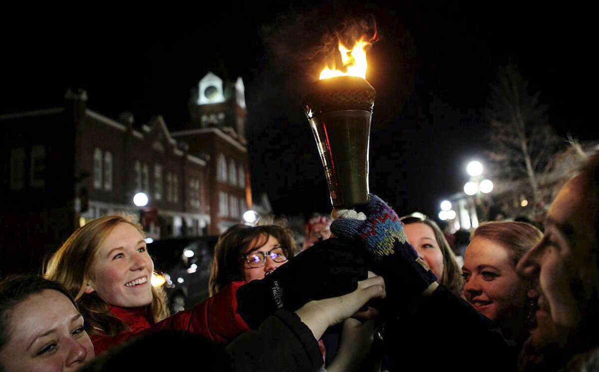 In this Friday, Feb 5, 2016 photo provided by the Newport Recreation Department, queen contestants participate in the torch lighting during the opening ceremony of the 100th Newport Winter Carnival in Newport N.H. People for the Ethical Treatment of Animals, or PETA, launched a protest against one of the carnival events billed as a "Greased Pig on Ice," but withdrew it after learning there's no pig in the act. The event will feature a man dressed in a pig costume, being chased by kids on ice skates on the town common. (Beth Rexford/Newport Recreation Department via AP)
