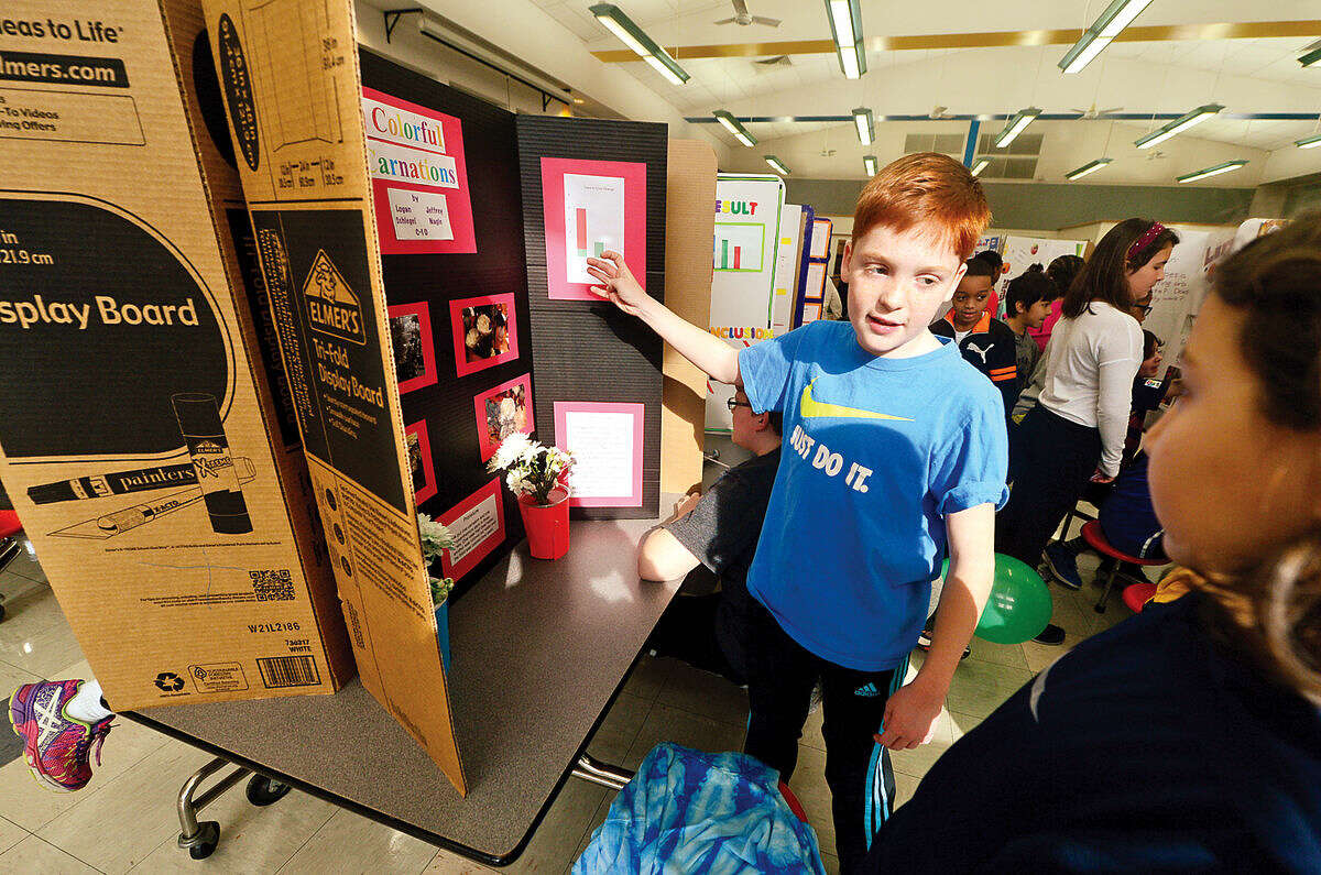 Hour photo / Erik Trautmann Fox Run Elementary School 5th grader Jeffrey Nagle's explains his science project, "Coloful Carnations", during the school's annual school Science Fair Friday.