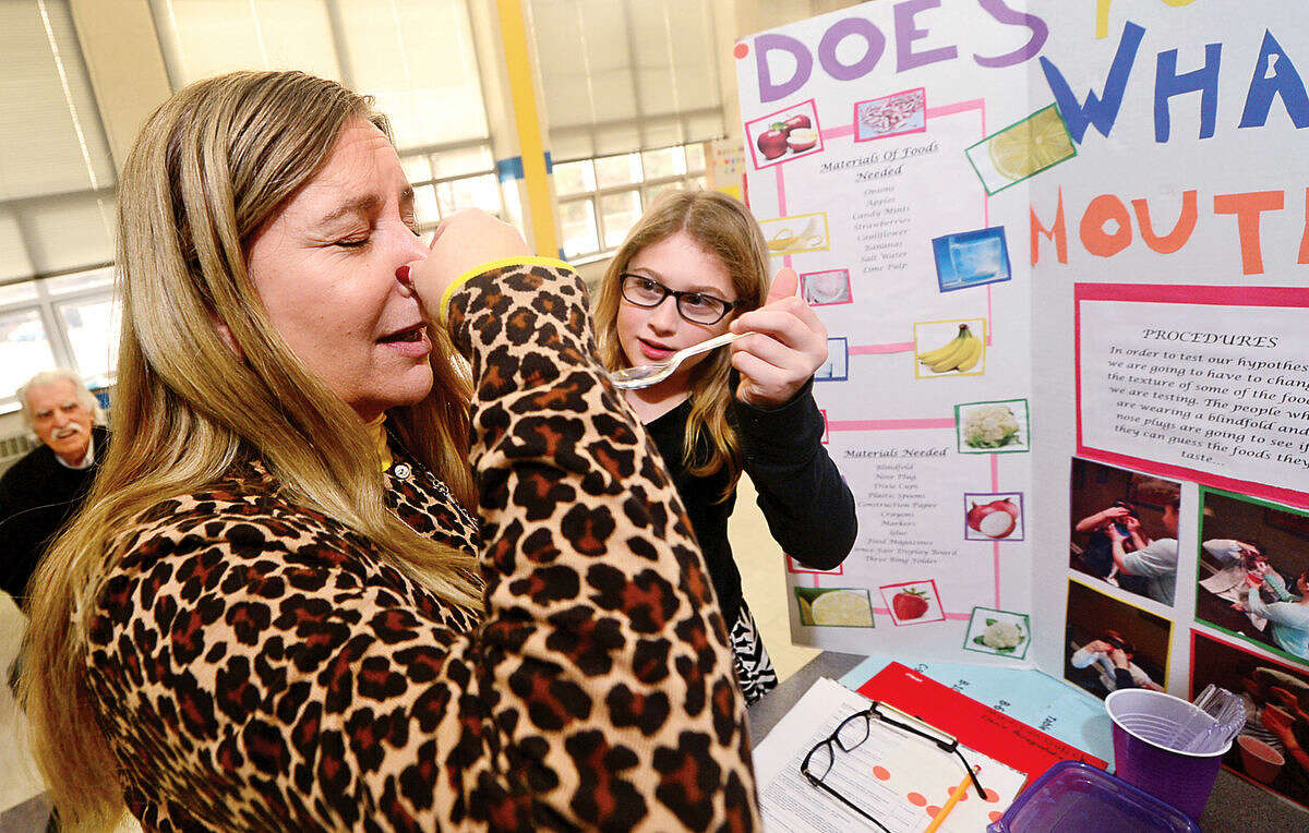 Hour photo / Erik Trautmann Fox Run Elementary School 5th grade teacher, Cindy Sila, judges 5th grader Madison Gulick's science project experiment, "Does Your Nose Know What Your Mouth Tastes", during the school's annual school Science Fair Friday.