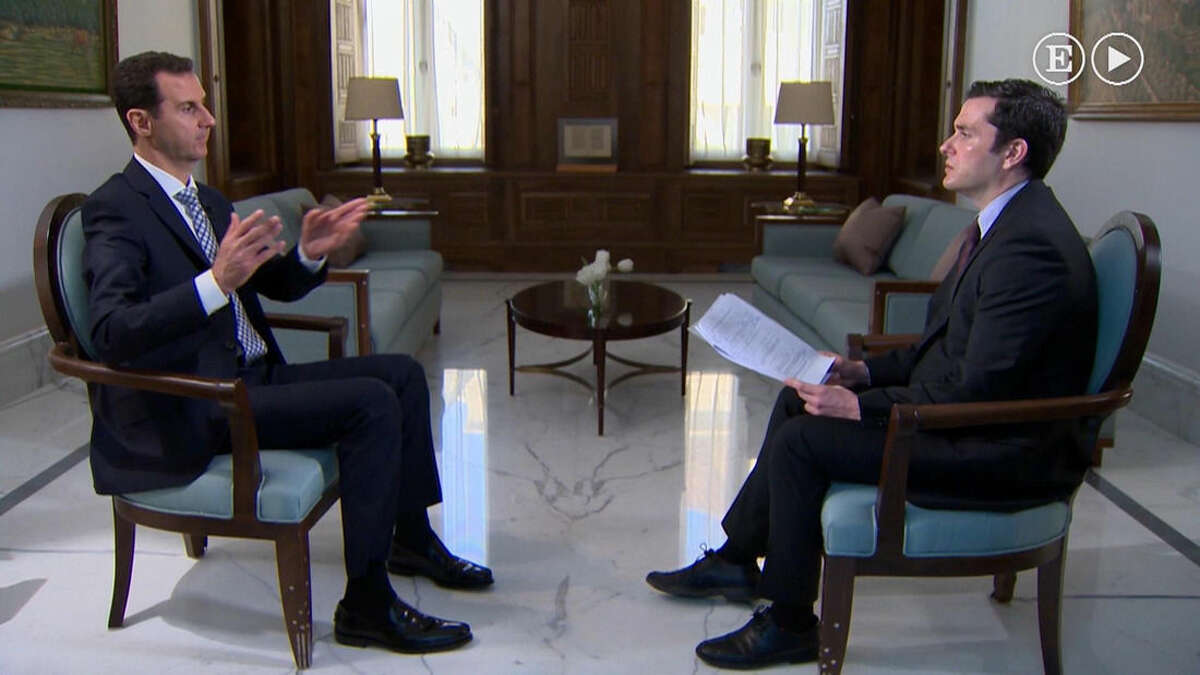 In this undated image made from video, Syrian President Bashar Assad, left, gestures while being interviewed in Damascus, Syria, by a journalist with Spanish El Pais newspaper published Sunday Feb. 21, 2016. During the interview Assad said that refugees can return to his country without fear of reprisals and asserted that the only way for regime change to happen in Syria is through a political process. (Syrian Presidency / El Pais video via AP) SPAIN OUT - NO CROPPING