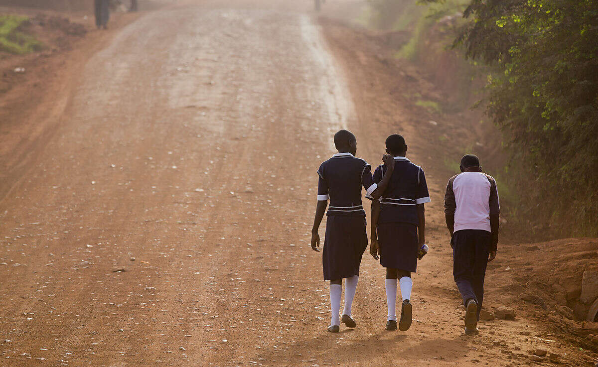 Ugandan children walk up a dusty murram road to school in the morning on the first day of the new term, in Kasangati, near Kampala, in Uganda Monday, Feb. 22, 2016. The new term started later than usual due to the recent presidential elections. (AP Photo/Ben Curtis)