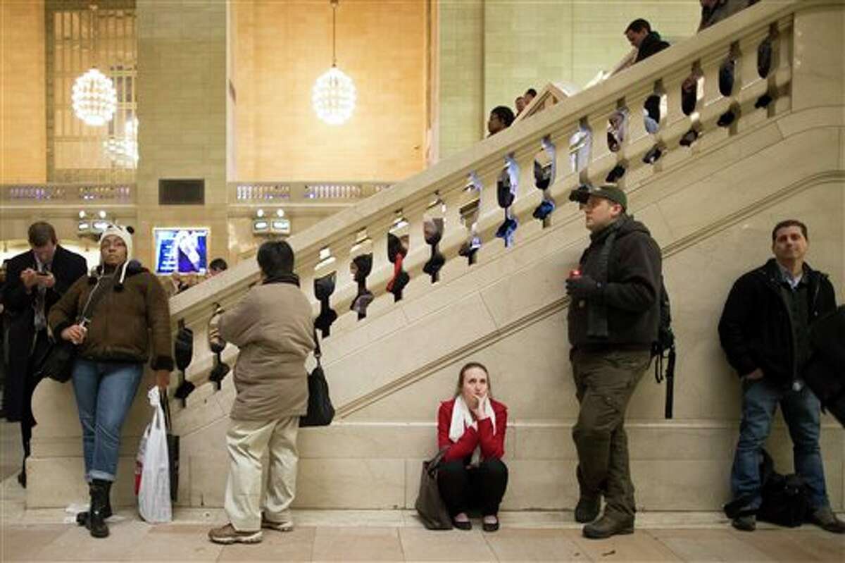 Commuters lean against a staircase in the main hall of Grand Central Station after a power problem with Metro-North Railroad's computer system caused the suspension of service on the Hudson, Harlem, and New Haven lines, Thursday, Jan. 23, 2014. Trains were brought to a halt for safety purposes while electricians worked to hook up temporary power to the computer system. Metro-North is the nation's second-busiest railroad and serves 281,000 riders a day in New York and Connecticut. 
