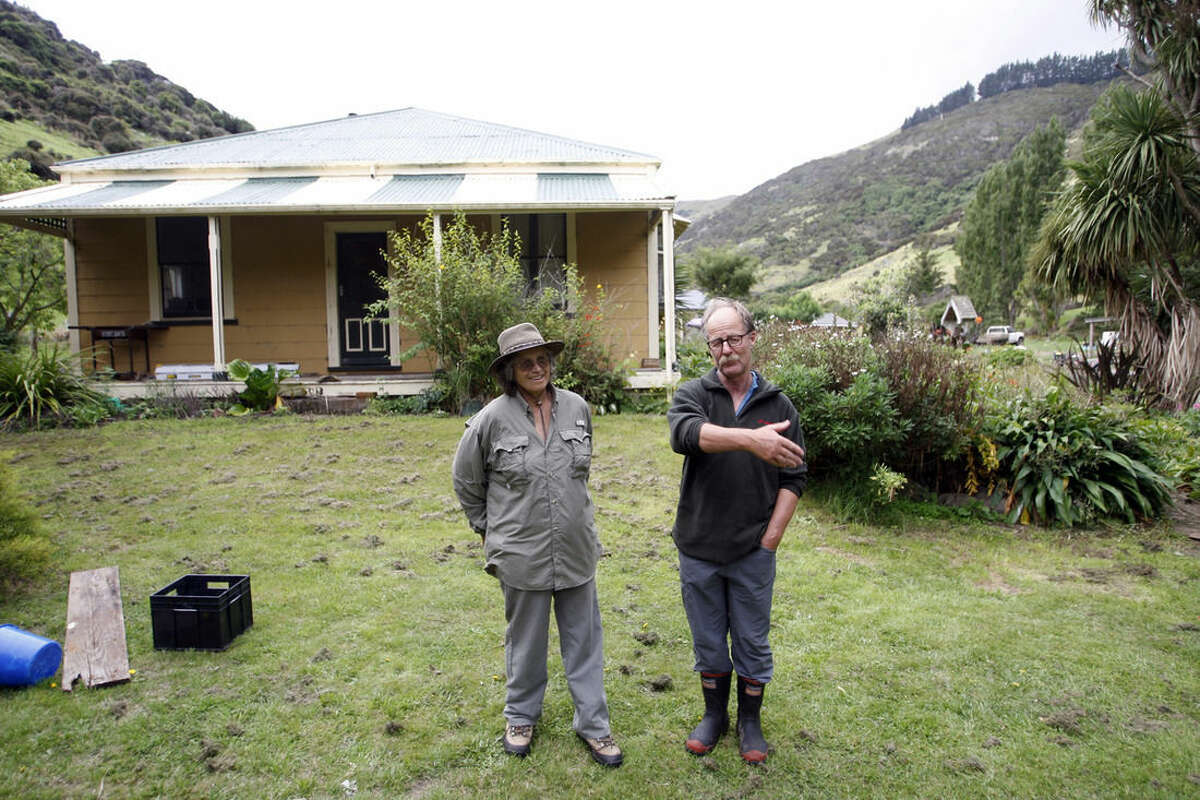 In this Feb. 8, 2016 photo, Shireen Helps and husband Francis Helps chat in front of their home in Flea Bay, New Zealand. Efforts by the Helps family over more than three decades helped save the bay’s penguins from predators while many nearby colonies were wiped out. (AP Photo/Nick Perry)