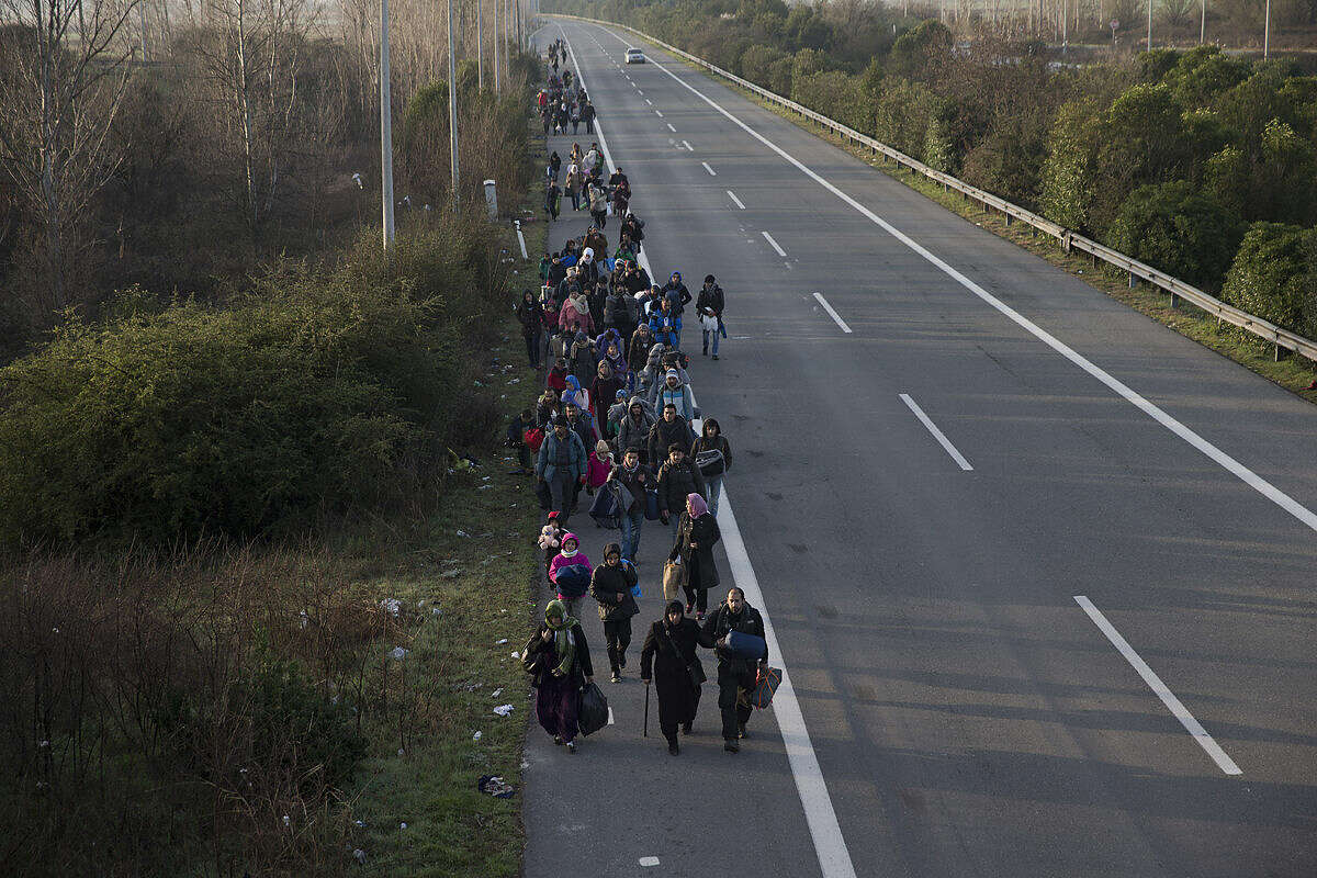 Refugees and migrants make their way to reach the borderline to Macedonia, near the northern Greek village of Idomeni, on Tuesday, Feb. 23, 2016. Police have removed hundreds of migrants from a camp during an operation at Greece's border with Macedonia following a protest that halted freight rail services to other Balkan countries. Journalists were not allowed to approach the area. (AP Photo/Petros Giannakouris)