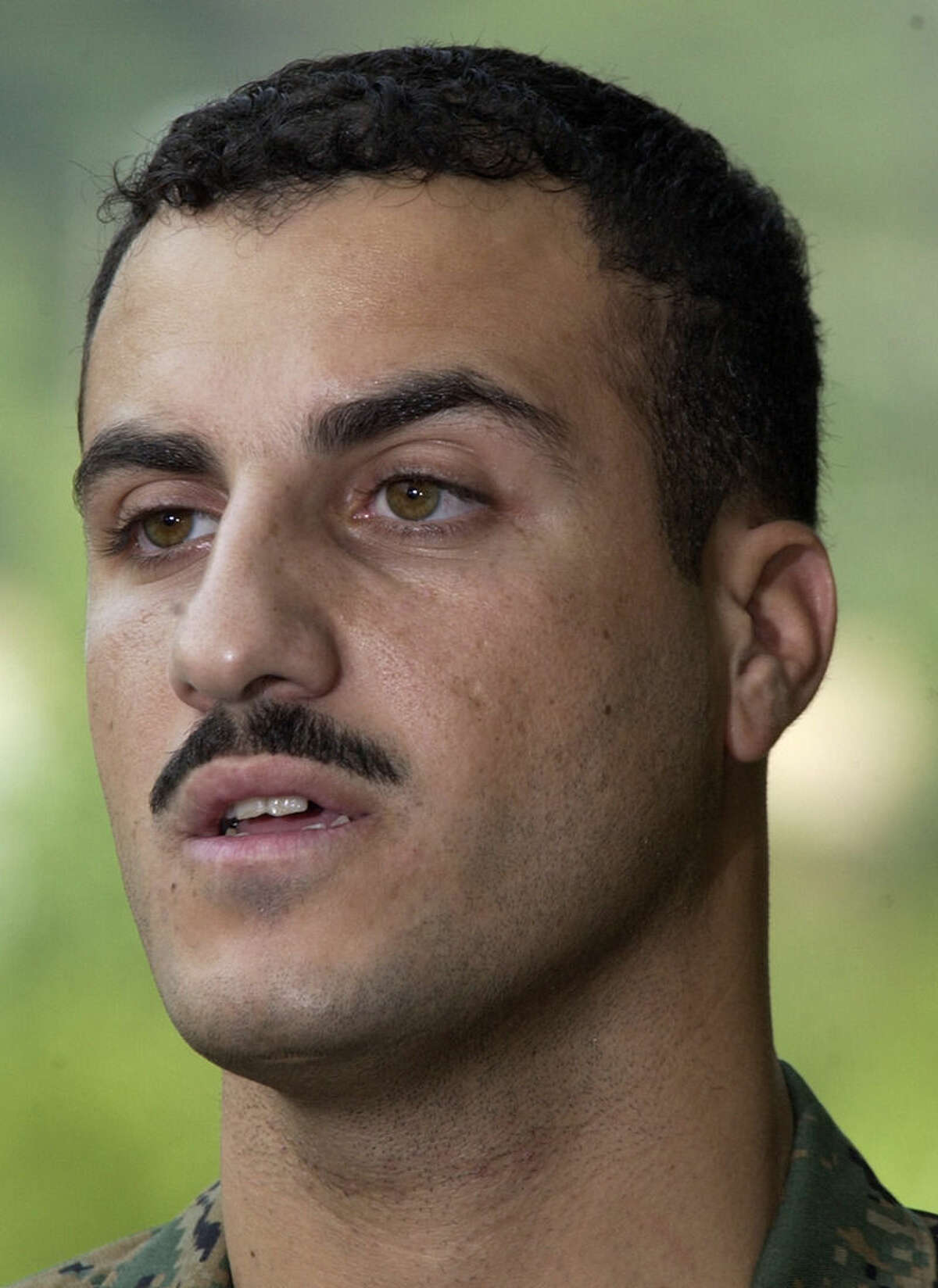 FILE - In this July 19, 2004 file photo, Marine Cpl. Wassef Ali Hassoun makes a statement to the press outside Quantico Marine Base in Quantico, Va. Hassoun's trial on desertion accusations starts Monday, Feb. 9, 2015 at Camp Lejeune, N.C. (AP Photo/Steve Helber, File)