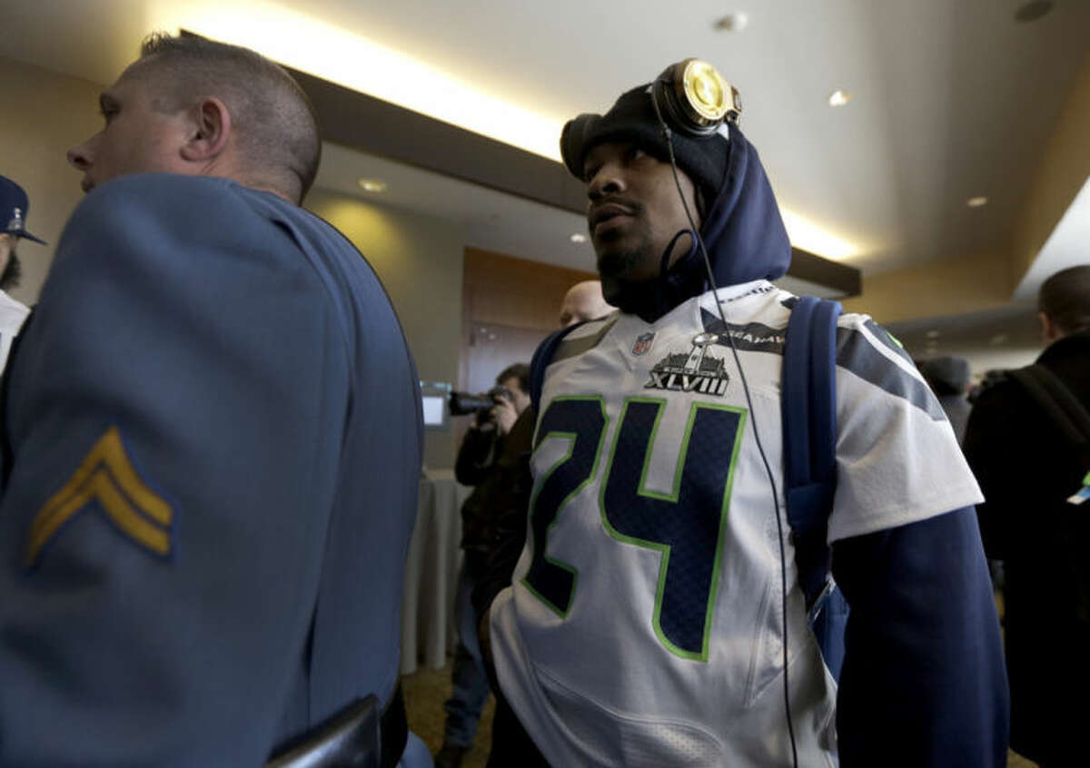 A member of the New Jersey state police escorts Seattle Seahawks running back Marshawn Lynch, right, through an area where a media availability was being held at the team's hotel Wednesday, Jan. 29, 2014, in Jersey City, N.J. The Seahawks and the Denver Broncos are scheduled to play in the Super Bowl XLVIII football game Sunday, Feb. 2, 2014. (AP Photo/Jeff Roberson)
