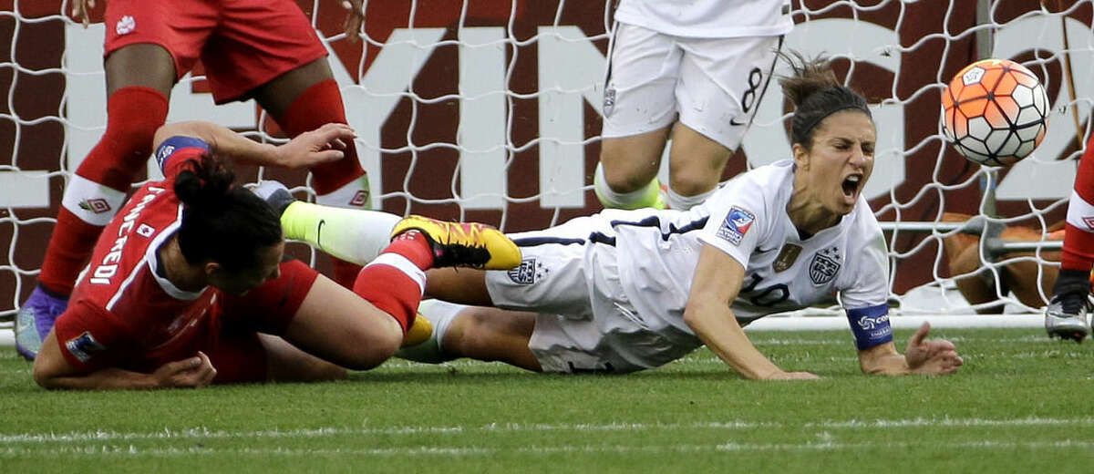 United States’ Carli Lloyd, right, falls with Canada's Melissa Tancredi, left, during the first half of the CONCACAF Olympic women's soccer qualifying championship final Sunday, Feb. 21, 2016, in Houston. (AP Photo/David J. Phillip)