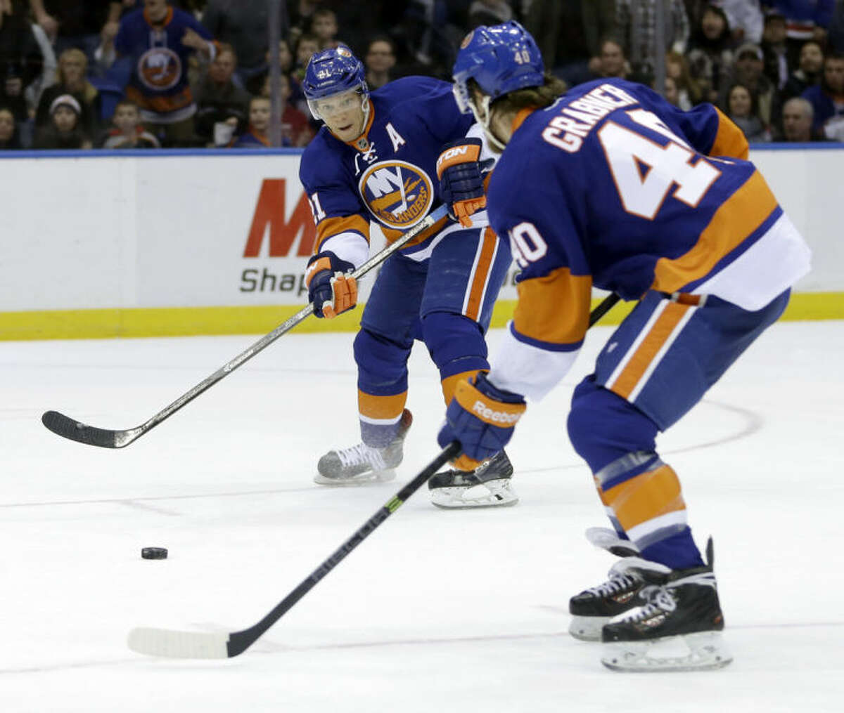 New York Islanders' Kyle Okposo, left, passes to Michael Grabner before scoring during the second period of the NHL hockey game against the Boston Bruins, Monday, Jan. 27, 2014, in Uniondale, New York. (AP Photo/Seth Wenig)