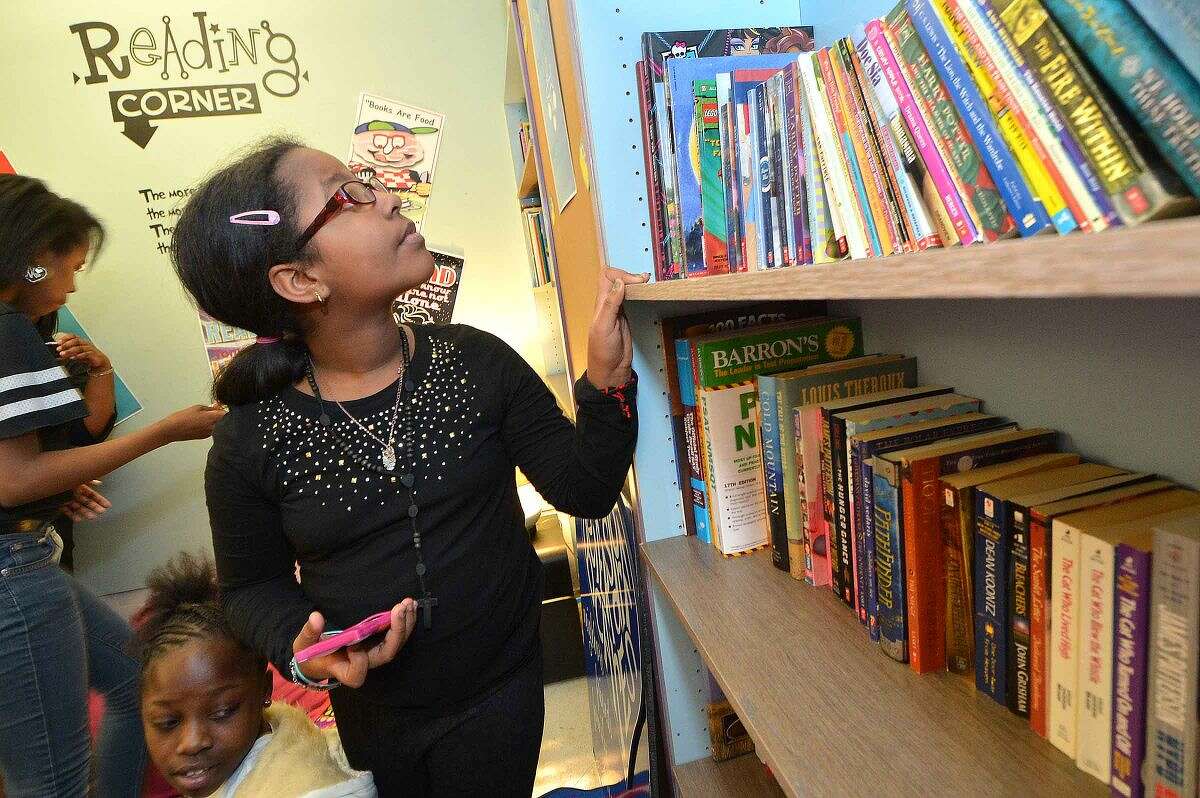 Ponus School sixth-grader Kimberly Castillo, 11, looks on the bookshelf at the new Reading Corner provided by Beirsdorf at the 20 West Learning Center.