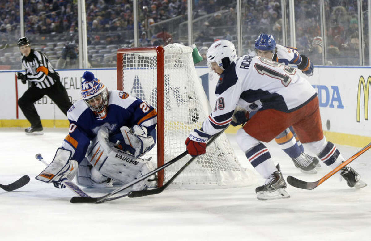 New York Islanders goalie Evgeni Nabokov (20) blocks a shot by New York Rangers center Brad Richards (19) in the second period of an outdoor NHL hockey game at Yankee Stadium in New York, Wednesday, Jan. 29, 2014. (AP Photo/Kathy Willens)