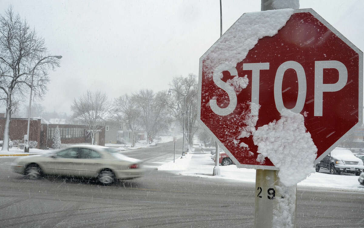 Snow clings to a stop sign at an intersection in Kankakee , Ill., Wednesday, Feb. 24, 2016. A powerful storm is moving through parts of the Midwest could dump more than a foot of snow in places. (Mike Voss/The Daily Journal via AP)