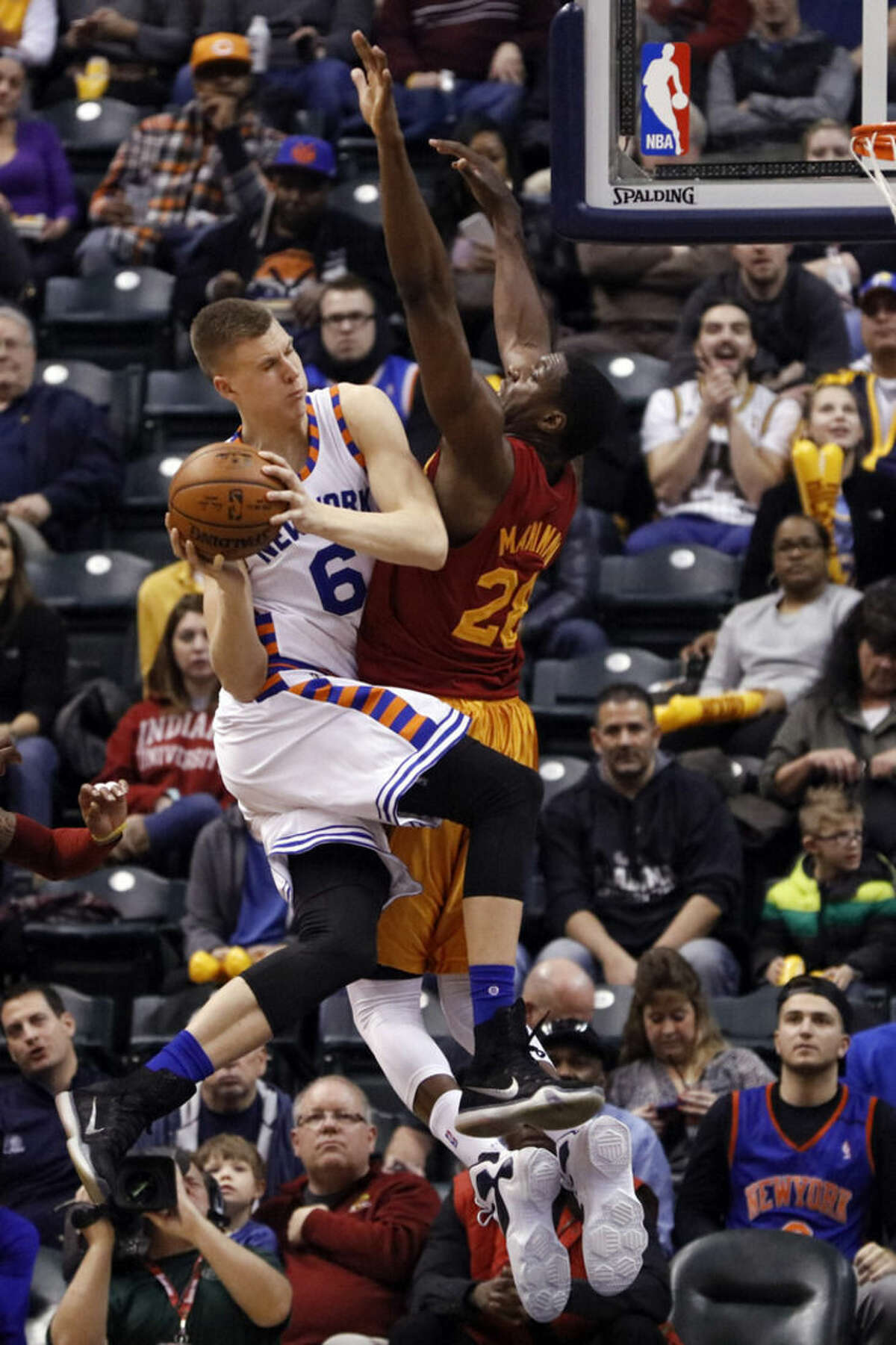New York Knicks forward Kristaps Porzingis, left, passes around Indiana Pacers center Ian Mahinmi during the second half of an NBA basketball game in Indianapolis, Wednesday, Feb. 24, 2016. The Pacers won 108-105. (AP Photo/AJ Mast)