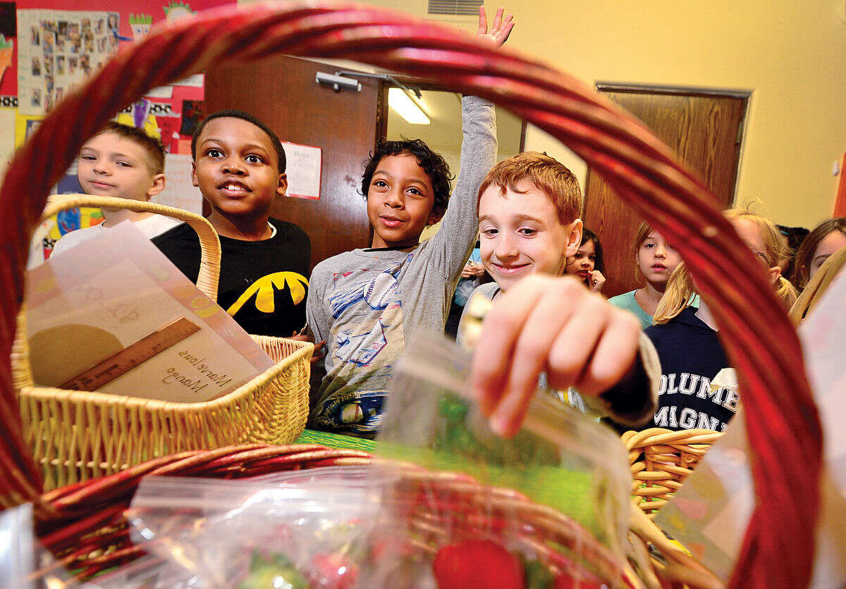 Hour photo / Erik Trautmann Columbus Magnet School students Devin Eason, Amir Miquel Walker-Silva and Jordan Bagnara shop for produce during the school's annual Berry-Go Round First Grade Market. Each year the First Grade hallway is transformed into a produce market offering fresh fruits and vegetables for purchase from the enterprising first graders.
