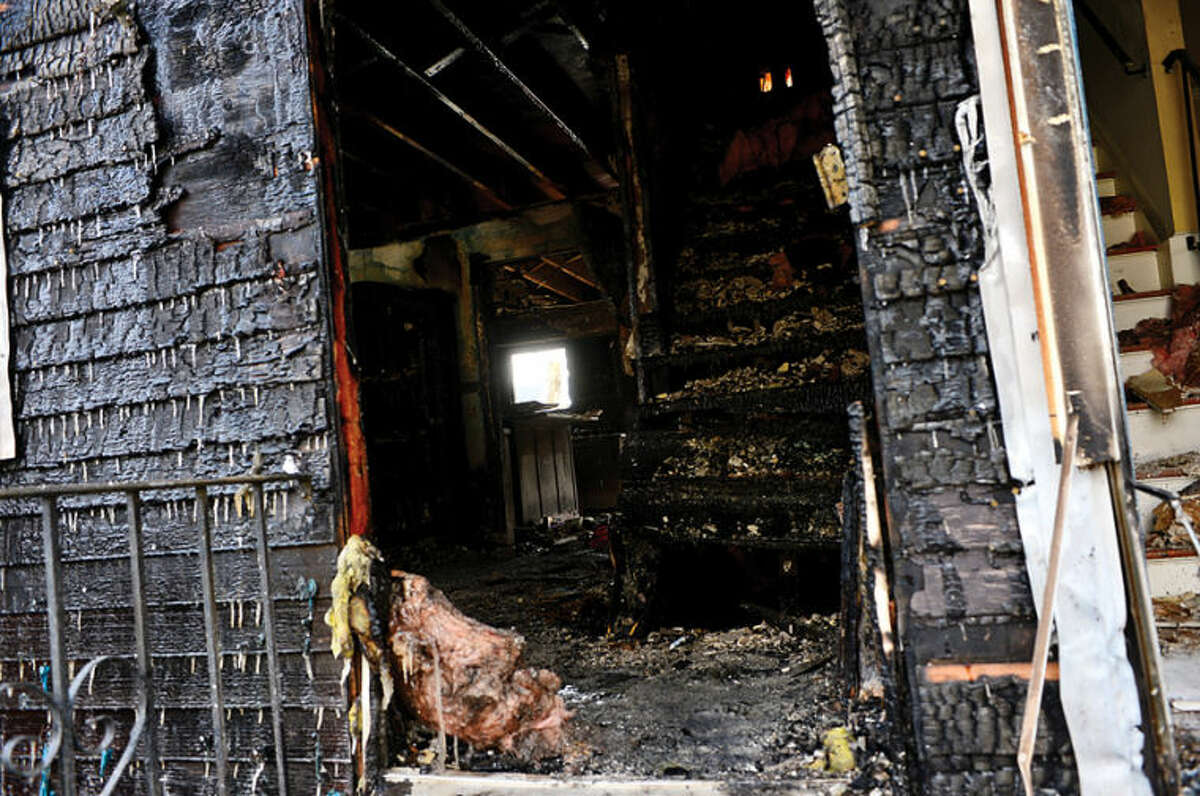 Hour photo / Erik Trautmann Norwalk fire inspectors comb through tthe duplex gutted by fire at 2am Friday morning.