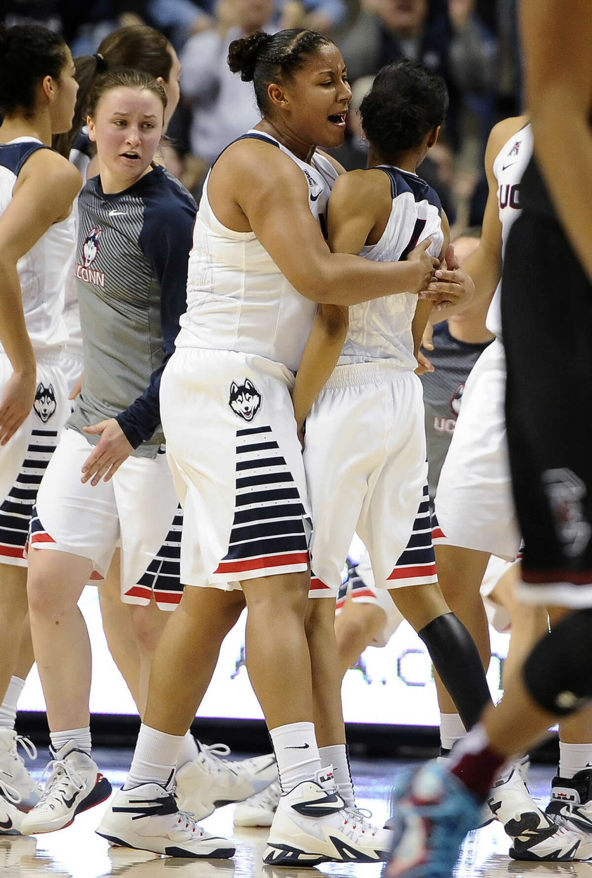 Connecticut’s Kaleena Mosqueda-Lewis, center, hugs teammate Moriah Jefferson, right, during the first half of an NCAA college basketball game, Monday, Feb. 9, 2015, in Storrs, Conn. (AP Photo/Jessica Hill)