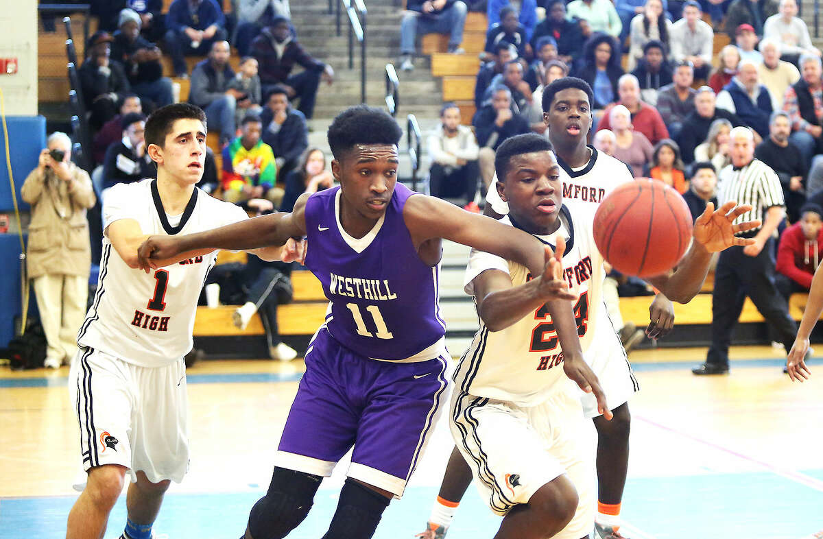 Westhill’s #11, Lenold Auguste, trys to get the ball from Stamford’s #24, Nii Pobee, during an FCIAC playoff game at Fairfield Ludlowe High School Saturday afternoon.