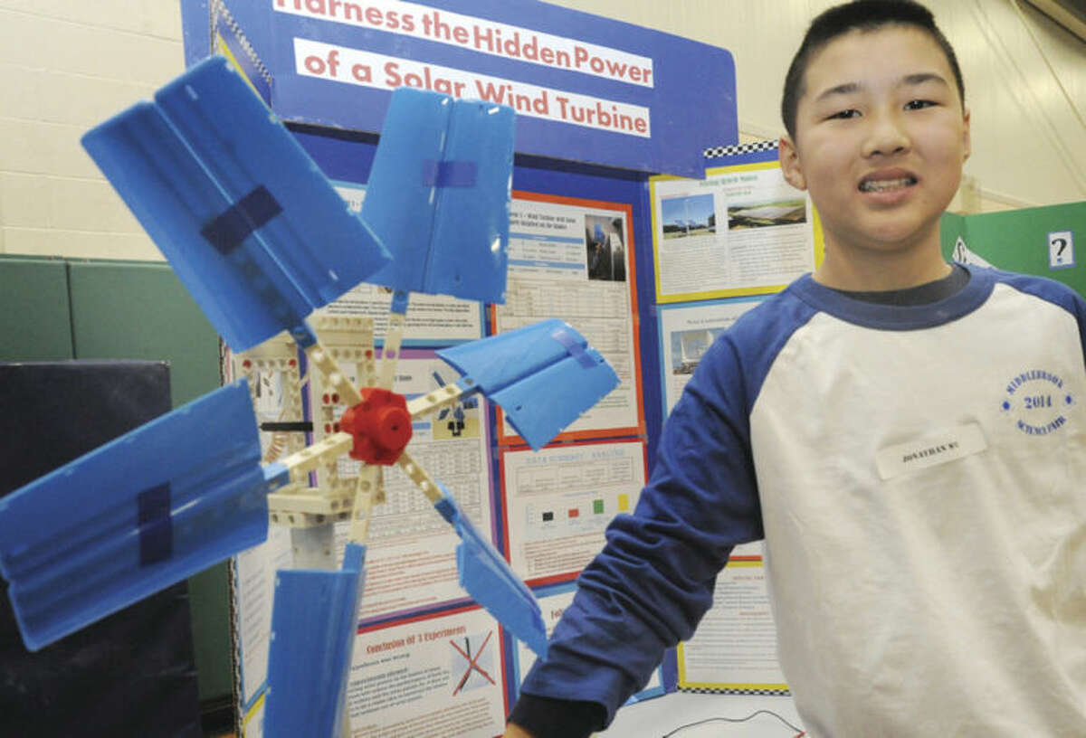 Hour photo / Matthew Vinci Seventh-grader Jonathan Wu stands next to his project, "Harness the Hidden Power of a Solar Wind Turbine" at the Middlebrook School Science Fair in Wilton on Tuesday.