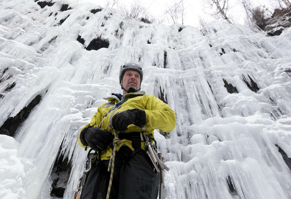 In this Wednesday, Feb. 10, 2016 photo, ice climber Don Mellor prepares to climb Pitchoff Quarry in Keene, N.Y. Mellor began ice climbing in the make-your-own tools era and has since introduced the sport to generations of students at a Lake Placid prep school where he is a teacher and counselor. He wrote the book, literally, on ice climbing in this rugged region. (AP Photo/Mike Groll)