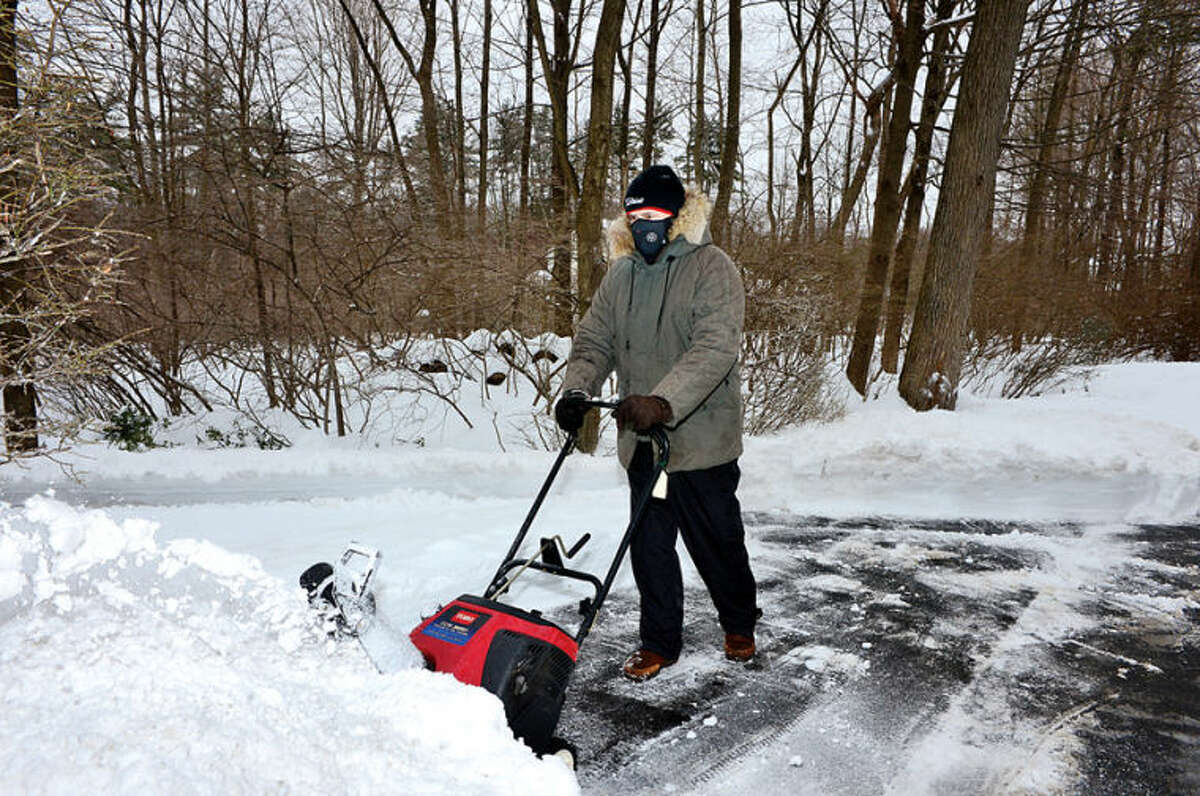 Hour photo / Erik Trautmann Len Pelletiere clears snow from his driveway in Wilton following the recent winter storm that left 5 inches of wet snow Wednesday morning.