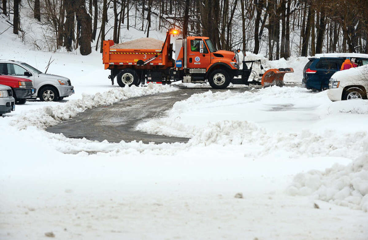 Hour photo / Erik Trautmann CT DPW trucks begins clearing the commuter lots where some vehicles were stranded following the recent winter storm that left 5 inches of wet snow Wednesday morning.