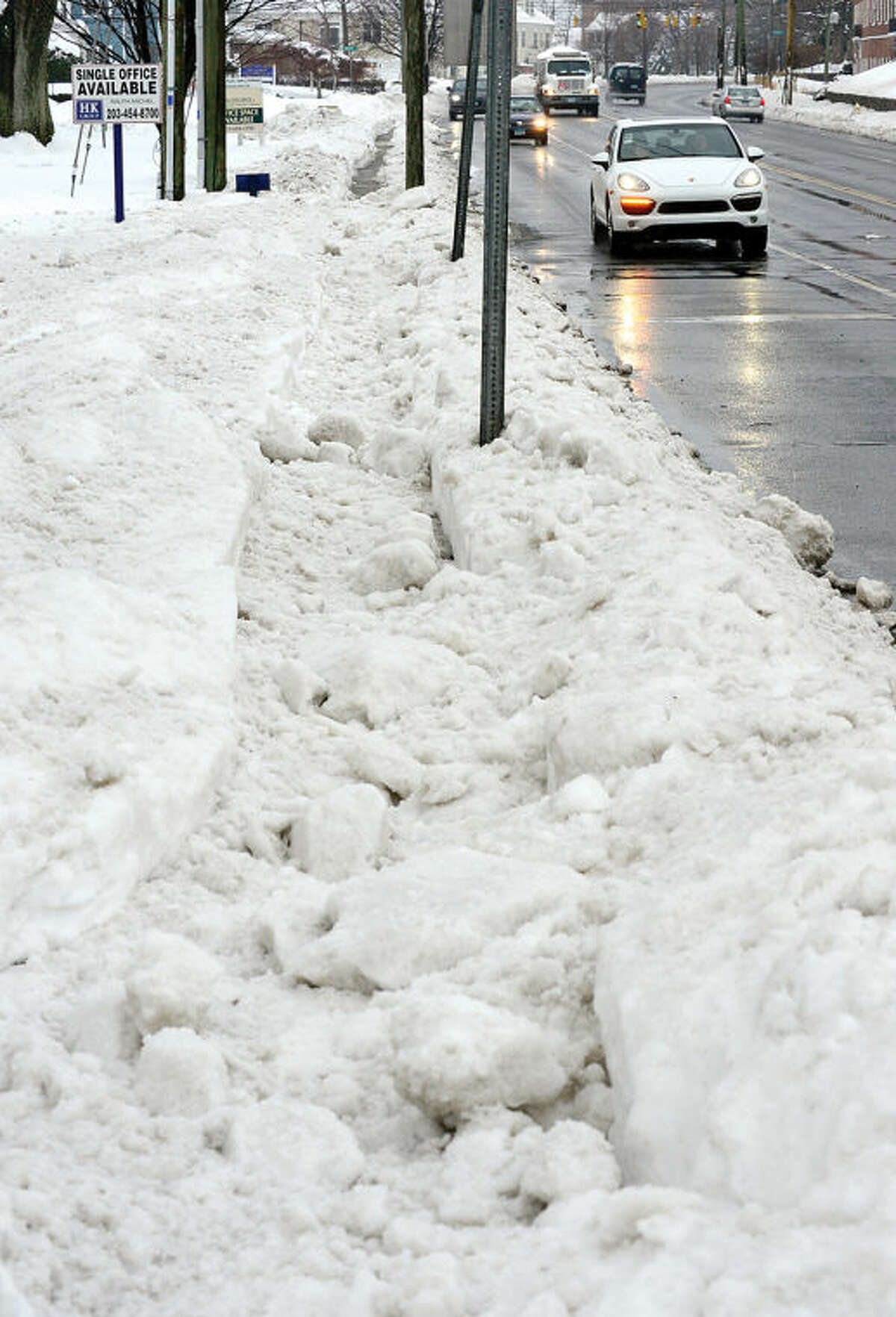 Hour photo / Erik Trautmann Once clear sidewalks on East Ave have been plowed over following the winter storm that left 5 inches of wet snow Wednesday morning.