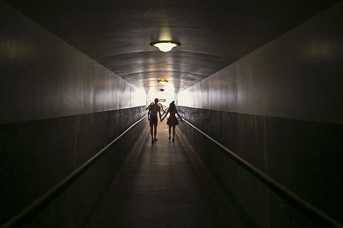 Performers Shauna Hackney, right, and Jared Hansen, dressed as “Metro Cupids,” walk into a tunnel at Union Station in Los Angeles, Friday, Feb. 13, 2015. Los Angeles Metro celebrates Valentine's Day a day early with its second annual "Speed Dating on the Red Line" event, helping passengers seeking to celebrate love while in transit. (AP Photo/Damian Dovarganes)