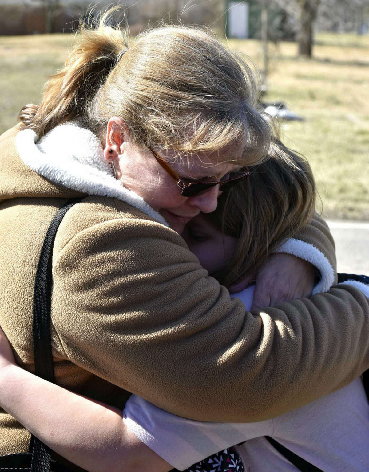 A child is comforted Monday, Feb. 29, 2016, near Middletown, Ohio after a school shooting at Madison Local Schools. An Ohio sheriff says a 14-year-old suspect in a school shooting that wounded four classmates, including two who were shot, is in a juvenile lock-up and facing several charges. Butler County Sheriff Richard Jones says the boy has been charged with two counts of attempted murder, two counts of felonious assault, inducing panic and making terrorist threats. (Nick Graham/Dayton Daily News via AP)