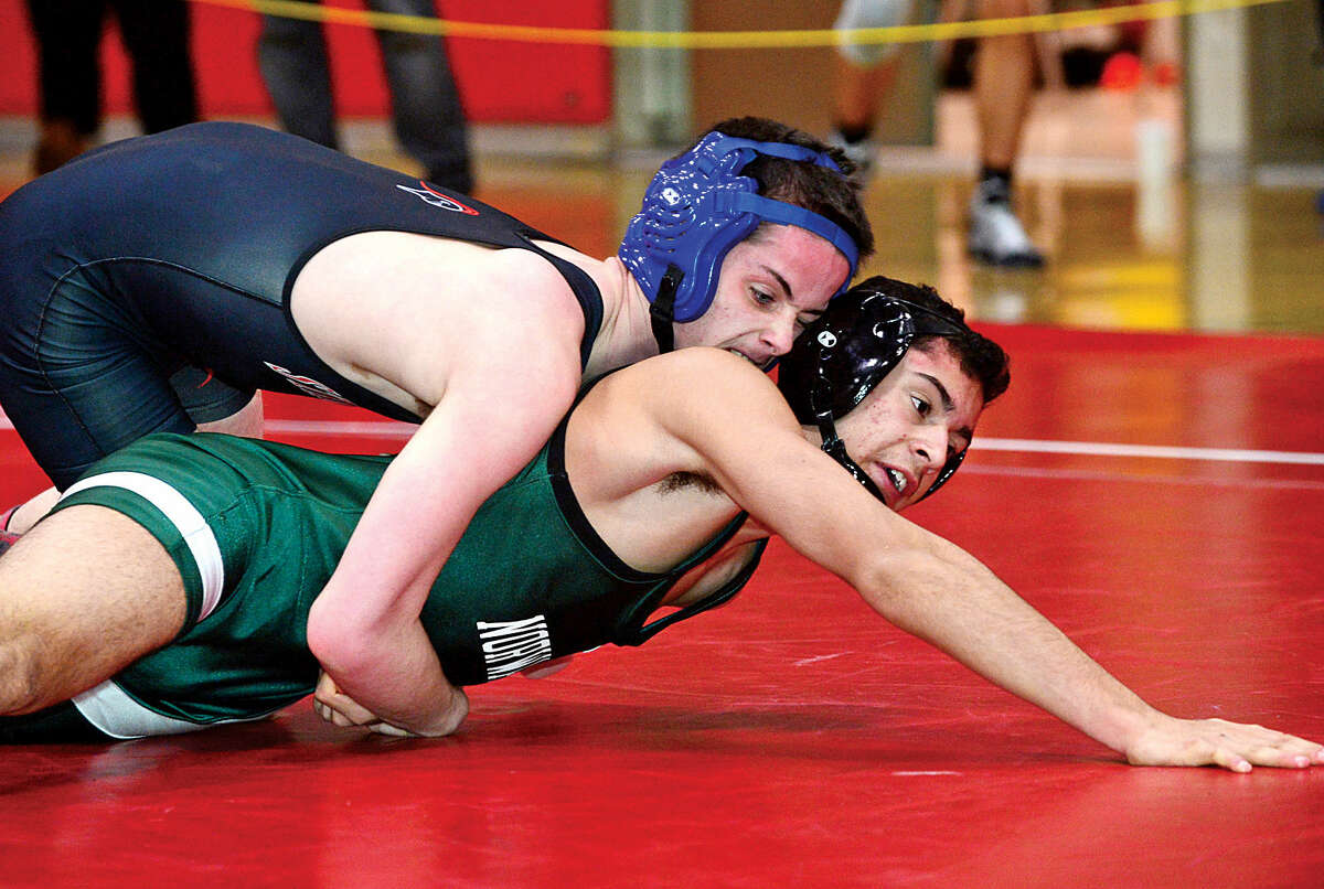 Hour photo / Erik Trautmann Local wrestlers Camilo Builes of Norwalk and Dominic Leckie of Stamford compete in the FCIAC Championship meet at New Canaan High School Saturday.